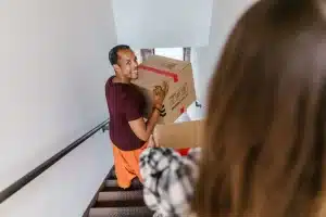 Man carrying cardboard box down the stairs